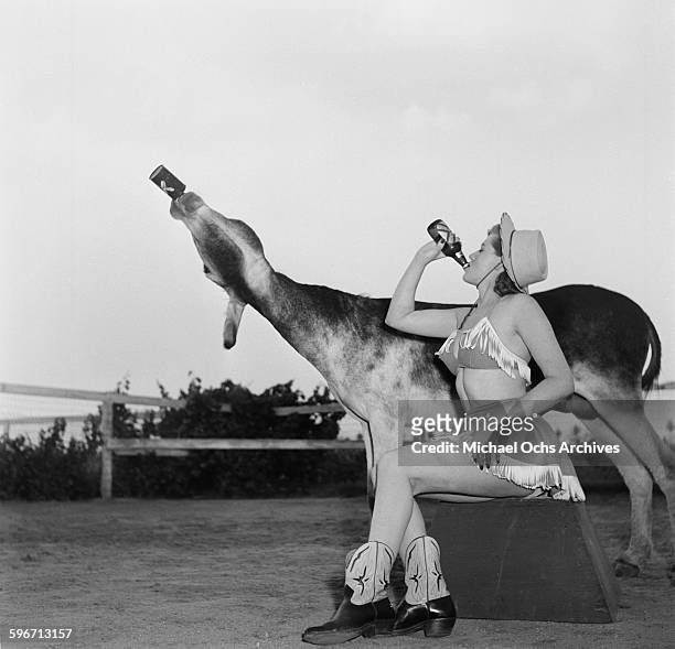 Betty Ames and her donkey Jackson drink from a bottle in Los Angeles,California.