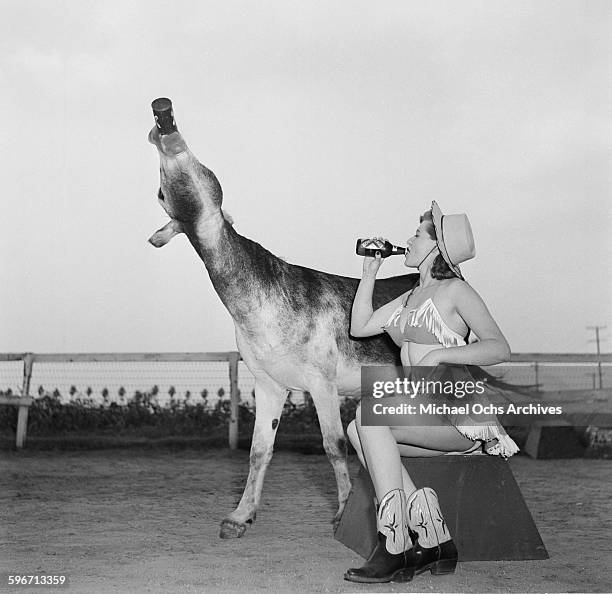 Betty Ames and her donkey Jackson drink from a bottle in Los Angeles,California.