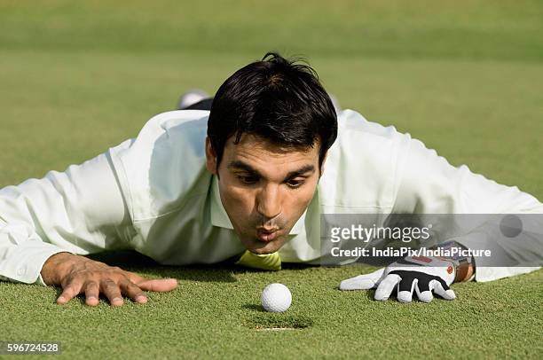 man looking at golf ball - golf cheating stock-fotos und bilder