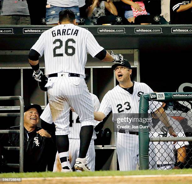 Avisail Garcia of the Chicago White Sox is congratulated by manager Robin Ventura and bench coach Rick Renteria after hitting a two run home run...