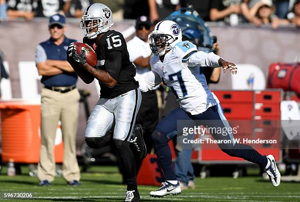 Wide receiver Michael Crabtree of the Oakland Raiders catches a 41 yard pass over defensive back Antwon Blake of the Tennessee Titans in the first...