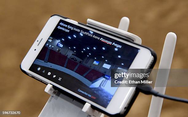Live feed from the camera of a DJI Phantom 4 drone in flight is displayed on a phone attached to the unit's control station during an AviSight Drone...