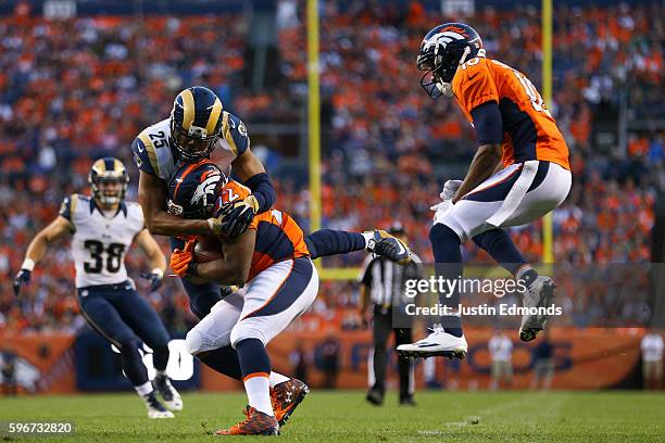 Strong safety T.J. McDonald of the Los Angeles Rams tackles running back C.J. Anderson of the Denver Broncos as Emmanuel Sanders and Cody Davis look...