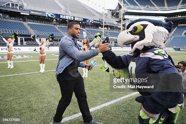 Seattle Seahawks player Bobby Wagner greets Blitz at American Express Dinner on the 50 at CenturyLink Field on August 27, 2016 in Seattle, Washington.