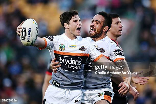 Mitchell Moses of the Tigers celebrates with teammate Dene Halatau after scoring a try during the round 25 NRL match between the New Zealand Warriors...