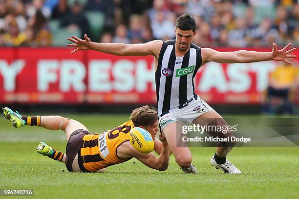 Taylor Duryea of the Hawks tackles Scott Pendlebury of the Magpies during the round 23 AFL match between the Hawthorn Hawks and the Collingwood...