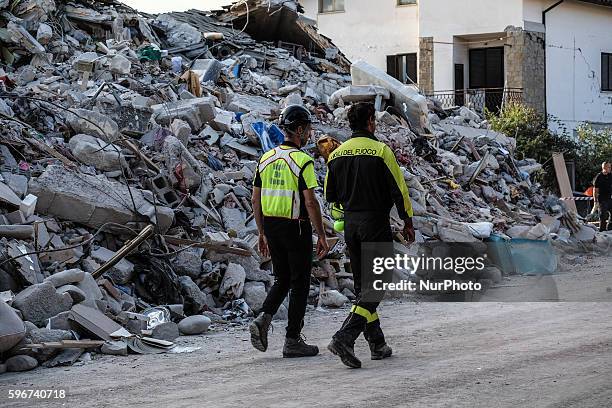 Firefighters walks near rubbles in Amatrice on August 26, 2016. Central Italy was struck by a powerful, 6.2-magnitude earthquake in the early hours,...