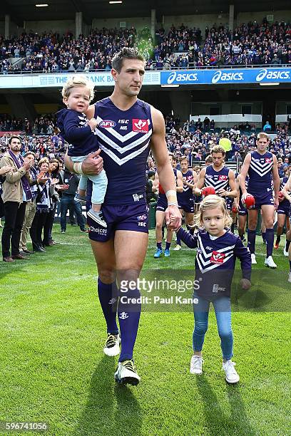 Matthew Pavlich of the Dockers leads his team onto the field with his children Jack and Harper before playing his final game during the round 23 AFL...