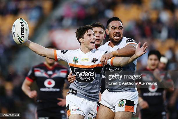 Mitchell Moses of the Tigers celebrates with teammate Dene Halatau after scoring a try during the round 25 NRL match between the New Zealand Warriors...