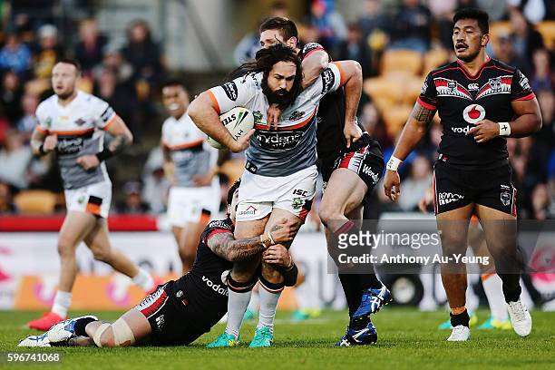 Aaron Woods of the Tigers is tackled by Issac Luke and Jacob Lillyman of the Warriors during the round 25 NRL match between the New Zealand Warriors...