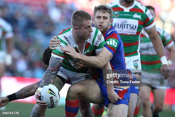 Aaron Gray of the Rabbitohs is tackled by the Knights defence during the round 25 NRL match between the Newcastle Knights and the South Sydney...