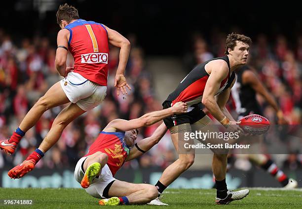 Blake Acres of the Saints is tackled by Pearce Hanley of the Lions during the round 23 AFL match between the St Kilda Saints and the Brisbane Lions...