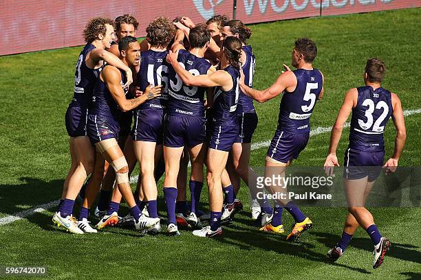 Matthew Pavlich of the Dockers is congratulated by team mates after kicking his 700th goal during the round 23 AFL match between the Fremantle...
