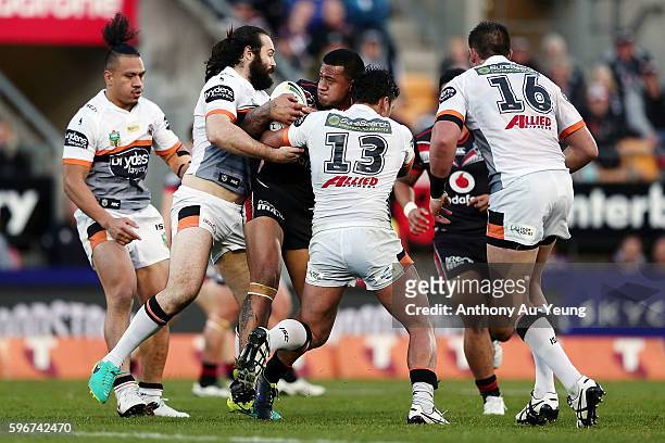 James Gavet of the Warriors charges into Elijah Taylor and Aaron Woods of the Tigers during the round 25 NRL match between the New Zealand Warriors...