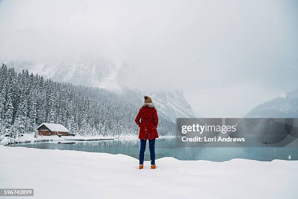 woman stands in front of lake louise alberta - lake louise stock-fotos und bilder