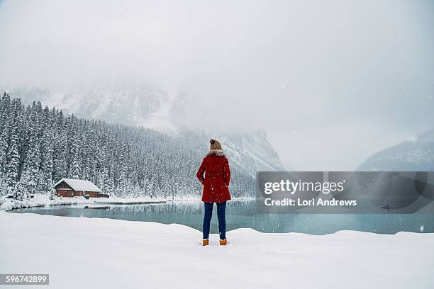 woman stands in front of lake louise alberta - lake louise ストックフォトと画像