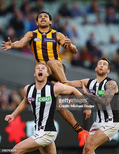 Cyril Rioli of the Hawks leaps on Jonathan Marsh of the Magpies during a contest during the round 23 AFL match between the Hawthorn Hawks and the...