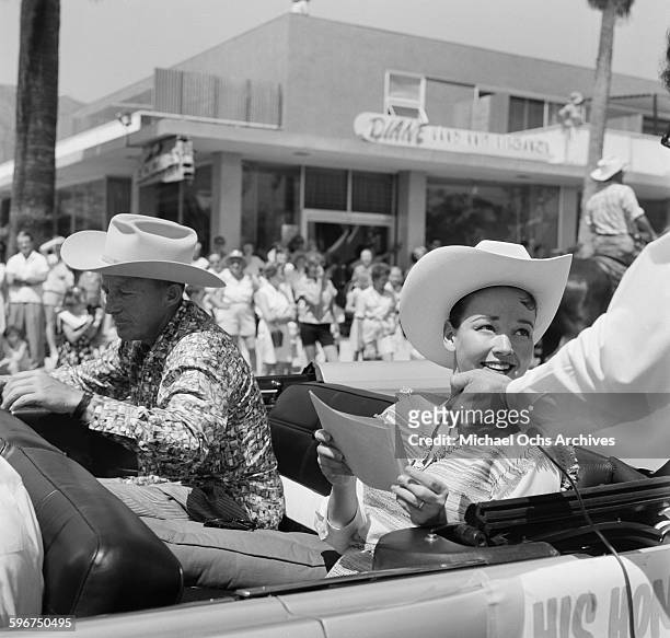 Actor and singer Bing Crosby and his wife Kathryn Crosby ride in a car during the 1958 Rose Parade in Pasadena, California.