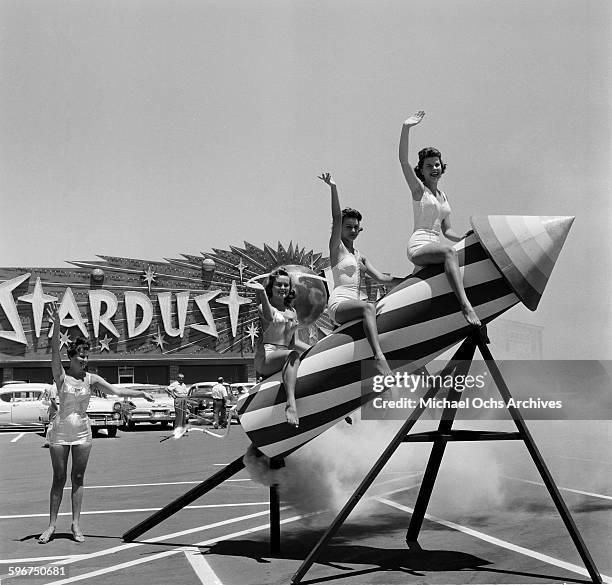 Women sit and pose on a rocket outside the new Stardust Resort and Casino in Las Vegas, Nevada.