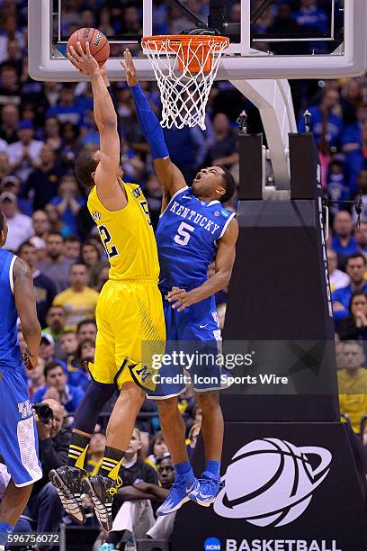 Kentucky Wildcats guard Andrew Harrison battles with Michigan Wolverines forward Jordan Morgan in action during the Div I Men's Championship - Elite...