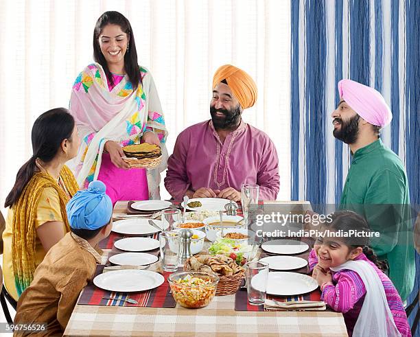 sikh family having lunch - sikhisme stockfoto's en -beelden