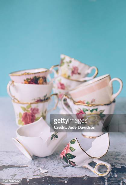 collection of pretty floral teacups with one broken tea cup - broken cup stock-fotos und bilder