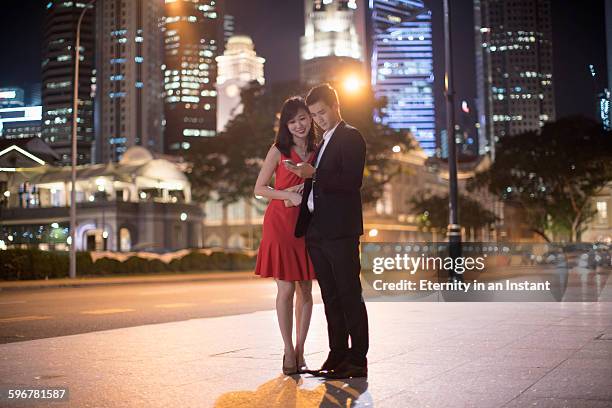 young couple on a date in the city at night. - well dressed couple stock pictures, royalty-free photos & images