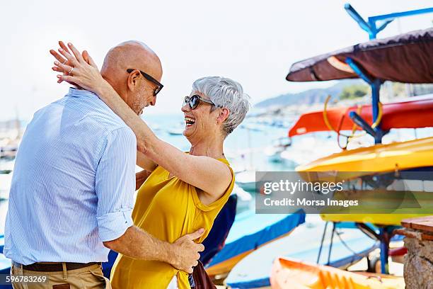 cheerful senior couple dancing by harbor - couple short hair stock-fotos und bilder