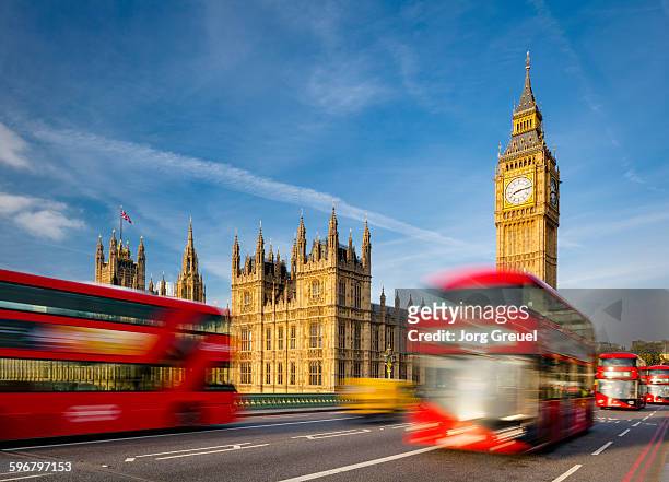 palace of westminster and big ben - london buses stock-fotos und bilder