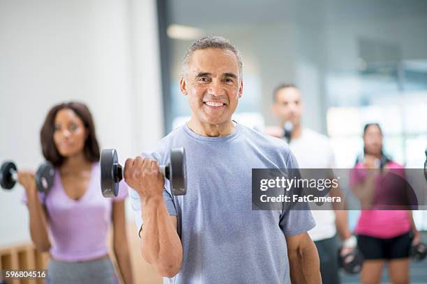 bicep curls - group of people flexing biceps stock pictures, royalty-free photos & images