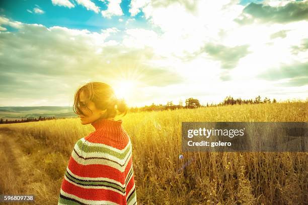 mujer con poncho en paisaje de verano a la hora del atardecer - origins fotografías e imágenes de stock