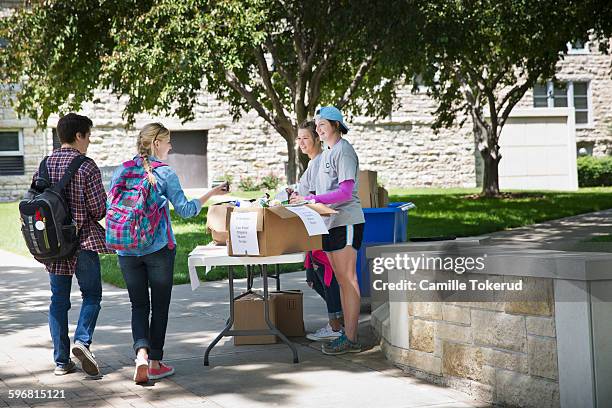 college volunteers hosting a food drive - charity drive stock pictures, royalty-free photos & images