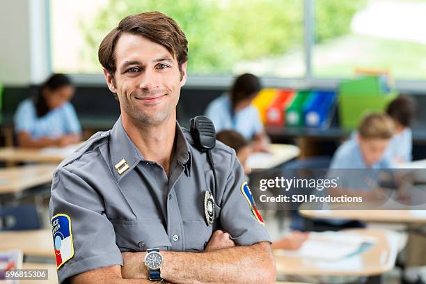 confident security officer in front of class of children - security guard stock pictures, royalty-free photos & images