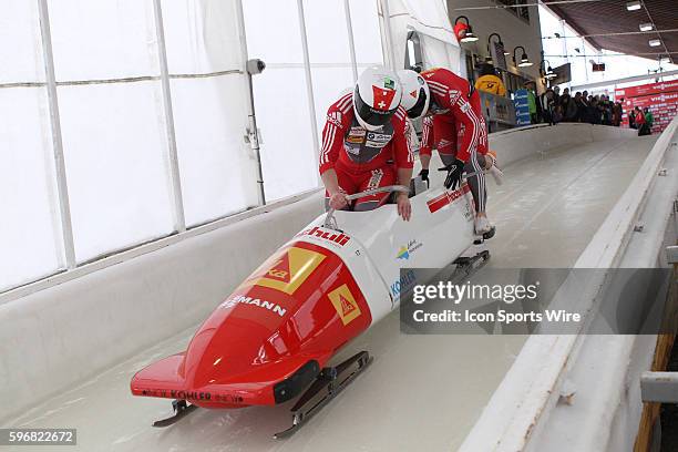 The Swiss 1 bobsled driven by Rico Peter with sidepushers Janne van der Zijde and Thomas Amrhein, and brakeman Simon Friedli slides on the track in...