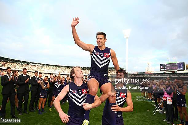 Matthew Pavlich of the Dockers is chaired from the ground by David Mundy and Alex Silvagni after playing his 353rd and final game during the round 23...