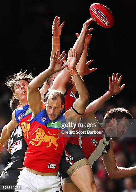 Josh Walker of the Lions, Eric Hipwood of the Lions and Sam Fisher of the Saints compete for the ball during the round 23 AFL match between the St...