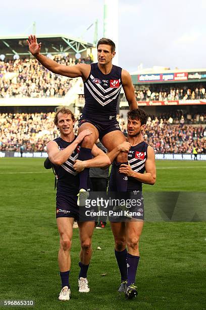 Matthew Pavlich of the Dockers is chaired from the ground by David Mundy and Alex Silvagni after playing his 353rd and final game during the round 23...