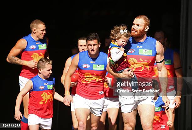 Daniel Merrett of the Lions leads his side onto the field during the round 23 AFL match between the St Kilda Saints and the Brisbane Lions at Etihad...
