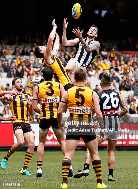 Jeremy Howe of the Magpies marks the ball over Marc Pittonet of the Hawks during the 2016 AFL Round 23 match between the Hawthorn Hawks and the...