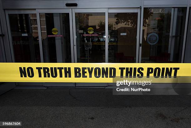 Participants of the Enough is Enough protest put yellow tape that reads No Truth Beyond This Point at the entrance to the CNN building in Los...