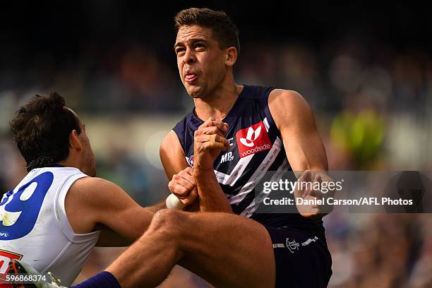 Stephen Hill of the Dockers is bumped in a kick by Tory Dickson of the Bulldogs during the 2016 AFL Round 23 match between the Fremantle Dockers and...