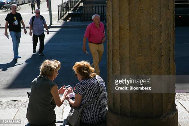 Pensioner shows her mobile device at Museum Island in Berlin, Germany, on Friday, Aug. 26, 2016. Germany's Bundesbank said raising the legal...