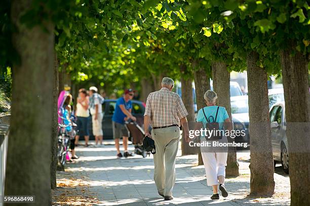 Pensioners hold hands as they walk in Sellin, Ruegen Island, Germany, on Saturday, Aug. 27, 2016. Germany's Bundesbank said raising the legal...