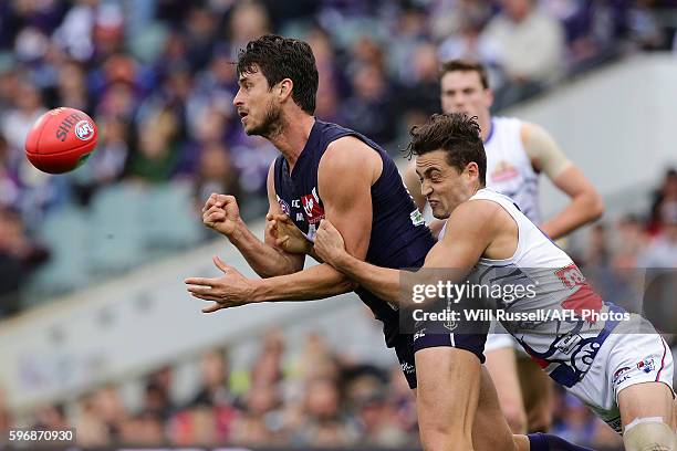Alex Silvagni of the Dockers handballs under pressure from Luke Dahlhaus of the Bulldogs during the round 23 AFL match between the Fremantle Dockers...