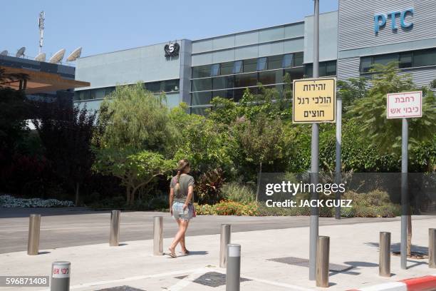 An Israeli woman walks in front of the building housing the Israeli NSO group, on August 28 in Herzliya, near Tel Aviv. - Apple iPhone owners,...