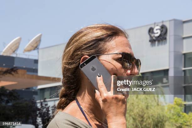 An Israeli woman uses her iPhone in front of the building housing the Israeli NSO group, on August 28 in Herzliya, near Tel Aviv. Apple iPhone...