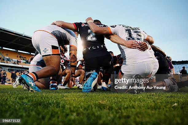 Players from both teams form a huddle after the round 25 NRL match between the New Zealand Warriors and the Wests Tigers at Mount Smart Stadium on...