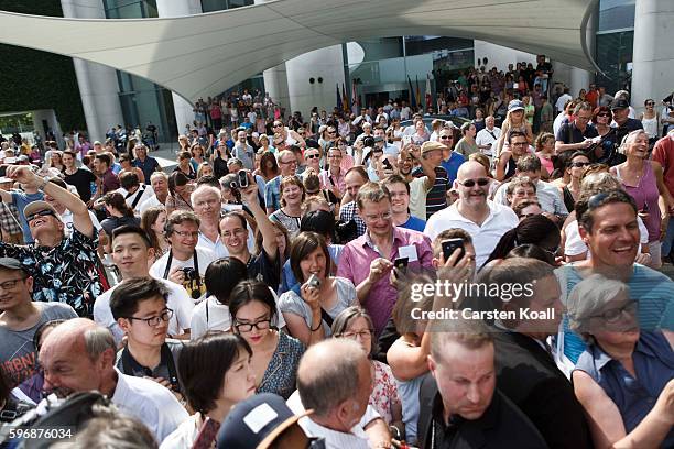 Members of the public follow a talk on the stage with German Chancellor Angela Merkel during the annual open-house day at the Chancellery on August...