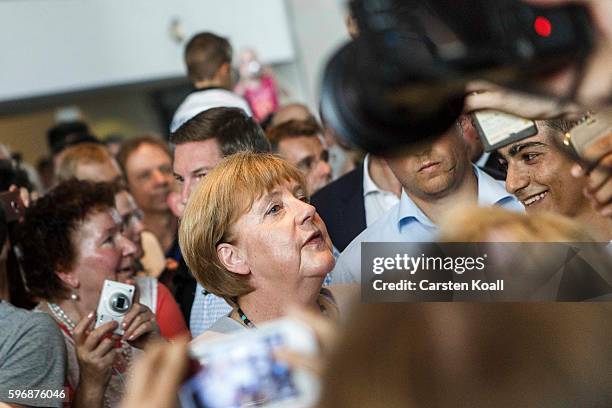 Visitors who had come for the annual open-house day take a photograph of German Chancellor Angela Merkel at the Chancellery on August 28, 2016 in...