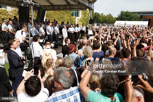 Members of the public follow a talk on the stage with German Chancellor Angela Merkel during the annual open-house day at the Chancellery on August...
